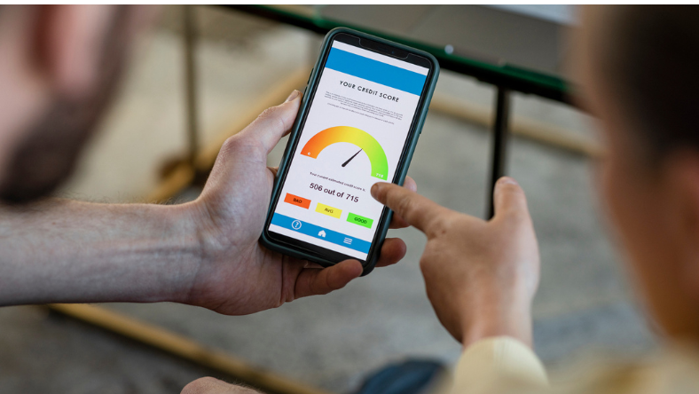 Hands holding mobile device displaying credit score screen