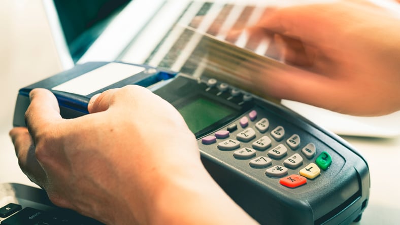 A credit card being swiped through a card reader