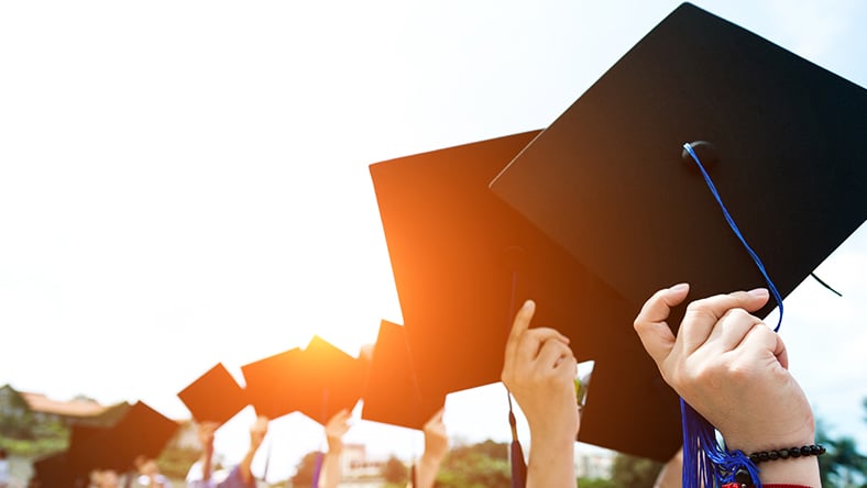 Students raising their graduation caps